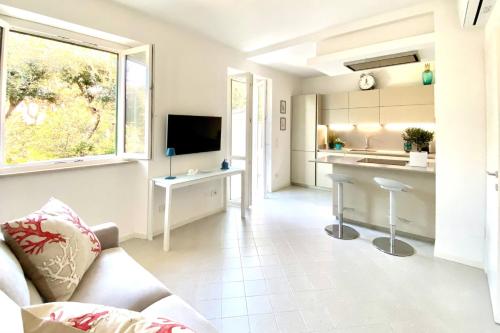 una cucina e un soggiorno con divano e TV di Via Zug a Castiglioncello
