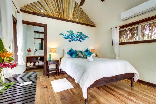 a bedroom with a large bed with blue pillows at Azure Del Mar in Maya Beach