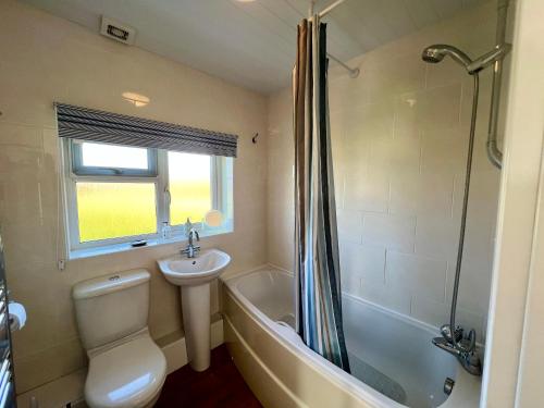 フレッシュウォーターにあるBAYVIEW self-catering coastal bungalow in rural West Wightの洗面台、トイレ、シャワー付きのバスルーム