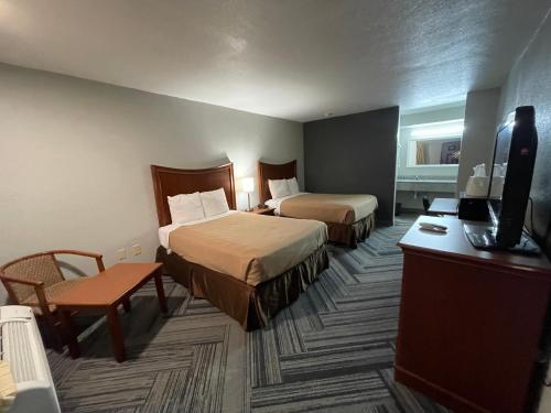 pokój hotelowy z 2 łóżkami i telewizorem z płaskim ekranem w obiekcie Raintree Inn w Adzie