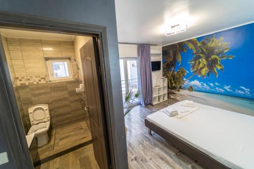 a bedroom with a bed and a bathroom with a painting on the wall at Philadelphia in Dubova