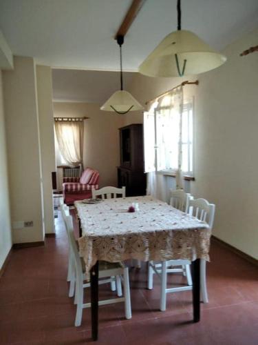 a dining room with a white table and chairs at Casa Mattioli in Mombaroccio