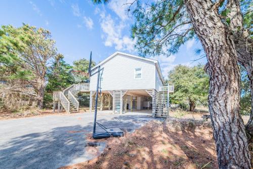 a white house with a tree in front of it at Coker Cabana in Sanderling