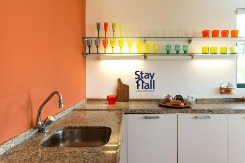 a kitchen with a sink and a sign that says stay hell at Apt Marulhos-Beira Mar-Melhor praia de Muro Alto-058M in Ipojuca