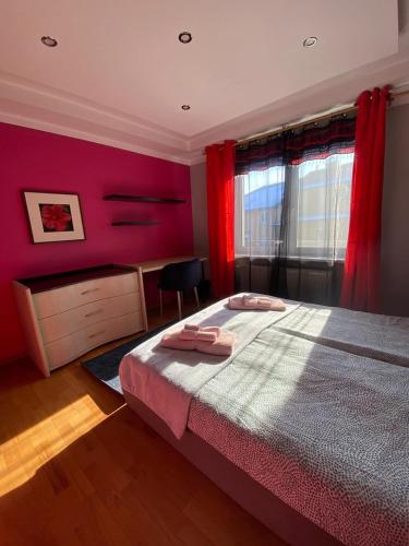 a bedroom with a bed and a red wall at Podkarpacka 50 in Rzeszów