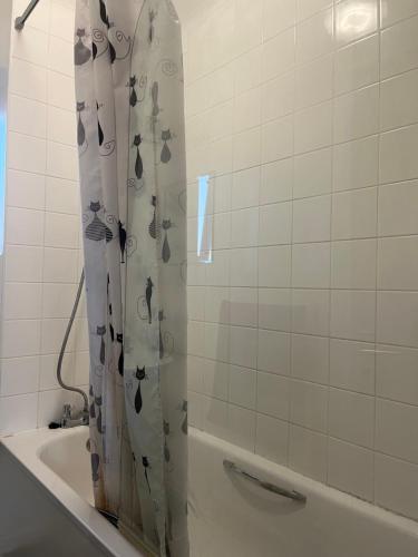 uma cortina de chuveiro na casa de banho com banheira em Addington House 4 beds em Londres