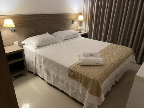 a bedroom with a bed with two towels on it at Apt tip flat midas riocentro jeunesse arena in Rio de Janeiro