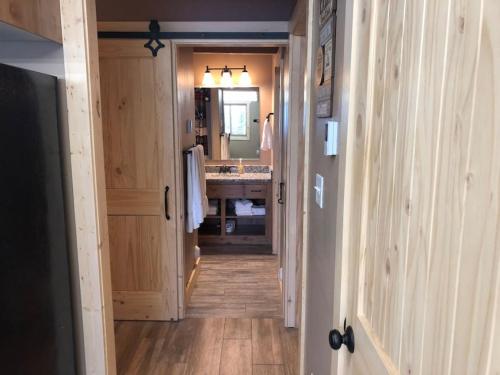 a hallway of a bathroom with a sink and a mirror at Heated Floors, Hot Tub, Grill in Island Park
