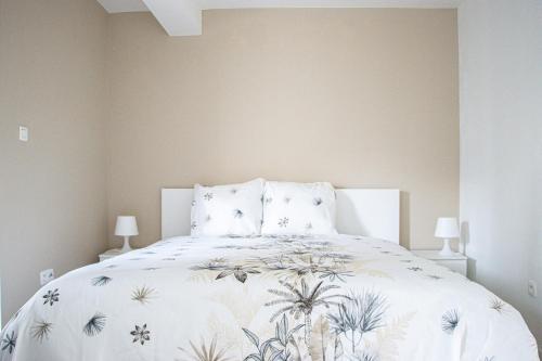 1 dormitorio con cama blanca y colcha de flores en NSD Home, en Amberes