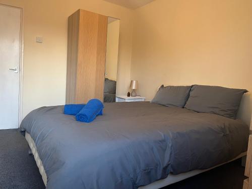 um quarto com uma cama com uma almofada azul em Addington House 4 beds em Londres