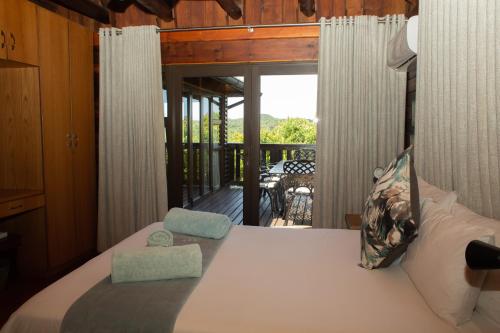1 dormitorio con 1 cama y balcón en Sodwana Bay Lodge House 34 en Sodwana Bay
