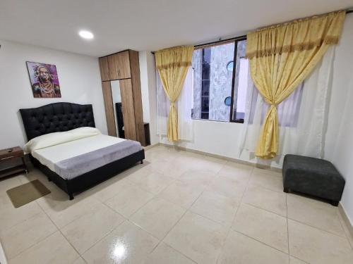 - une chambre avec un lit et une grande fenêtre dans l'établissement Las Margaritas apartments, Pereira City Centre, à Pereira