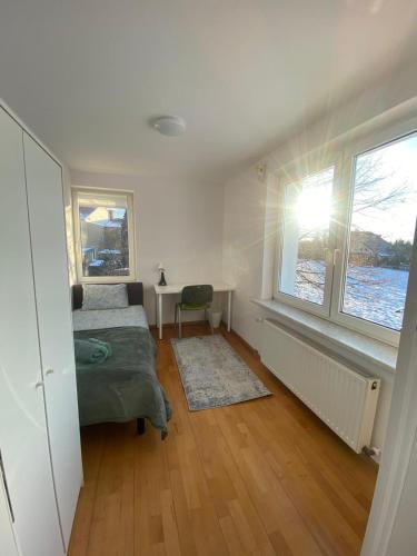 a bedroom with a bed and a desk and a window at Podkarpacka 50 in Rzeszów