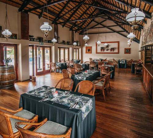 Mount Sheba Rainforest Hotel & Resort في بيلجريمريست: مطعم فيه طاولات وكراسي في الغرفة