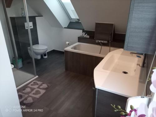 a bathroom with a tub and a toilet and a sink at 3-Raum Ferienwohnung in Willmersdorf - Thüringer Wald in Grossbreitenbach