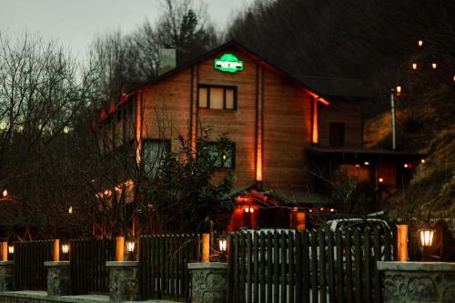 a house with a green sign on the side of it at Abant Yayla Dağevi in Dereceören