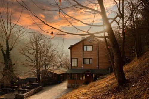 a house sitting on top of a hill with a sunset at Abant Yayla Dağevi in Dereceören