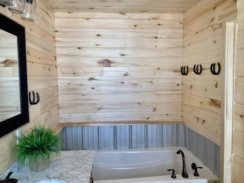 a bathroom with a tub and wooden wall at Newly Built, Fire Pit, Kitchen in Rea