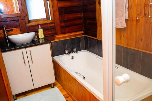 a bathroom with a bath tub and a sink at Sodwana Bay Lodge House 34 in Sodwana Bay