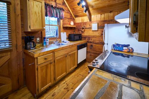 a kitchen with wooden cabinets and a white refrigerator at A Cabin In The Woods in Pigeon Forge