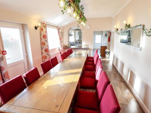 a conference room with a long table and red chairs at Bank House in Mablethorpe