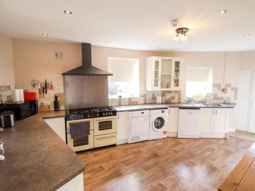 a large kitchen with white appliances and wooden floors at Bank House in Mablethorpe