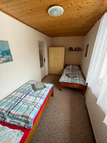 a room with two beds and a wooden ceiling at Ubytování Sedlařík Mladé Buky in Mladé Buky