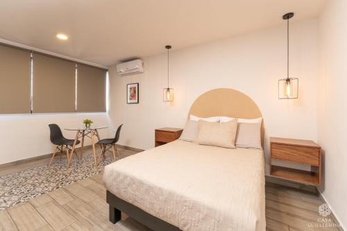 1 dormitorio con 1 cama, mesa y sillas en Casa Guillermina, en Durango