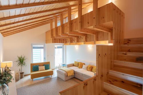 Apartamento Férias (Apartamento Norte) في كوستا نوفا: غرفة معيشة مع درج خشبي وأريكة