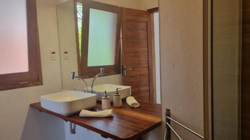 a bathroom with a sink and a mirror at Casa Mangue in Camocim