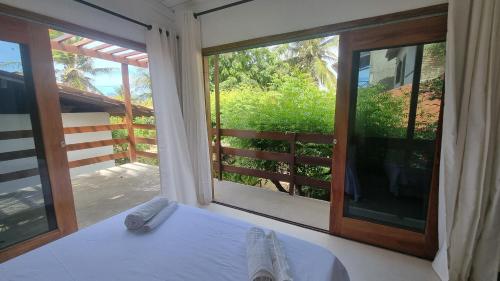 a room with a bed and a large window at Casa Mangue in Camocim