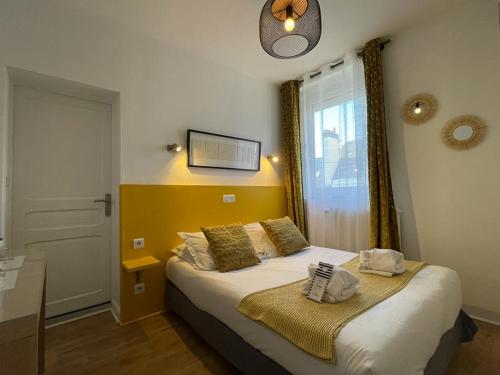 een slaapkamer met een bed en een raam bij Hôtel Jules in Le Touquet-Paris-Plage