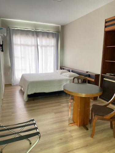 a bedroom with a bed and a table and a desk at Map Hotel in Lages