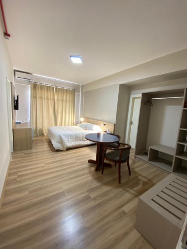 a bedroom with a bed and a table and a room with a bed gmaxwell gmaxwell at Map Hotel in Lages