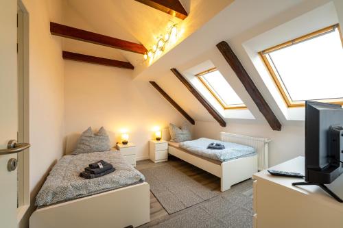 a attic room with two beds and a tv at Börde-Apartment 5 in Vahldorf