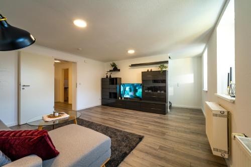 a living room with a couch and a flat screen tv at Börde-Apartment 5 in Vahldorf