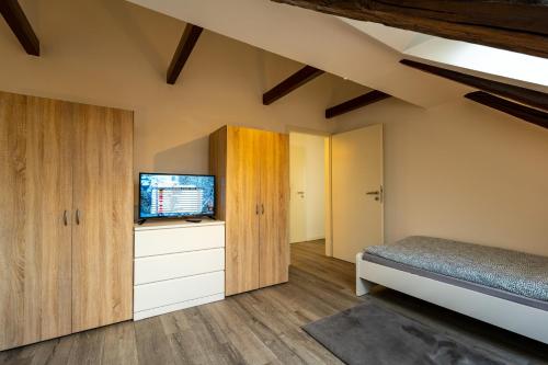 a bedroom with a bed and a flat screen tv at Börde-Apartment 5 in Vahldorf