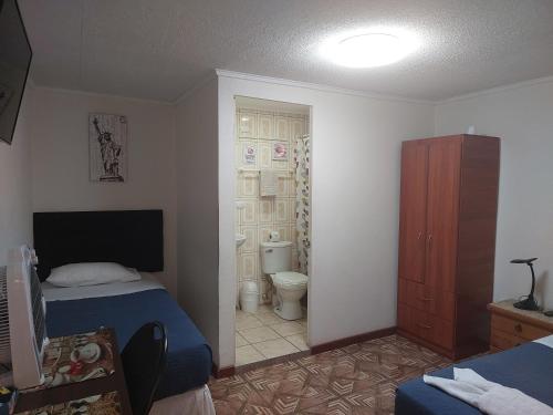 a bedroom with a bed and a bathroom with a toilet at Bellissa House in Antofagasta