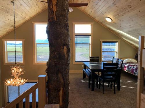 a dining room with a table and chairs and a bedroom at Patios, Hot Tub, Yellowstone in Rea