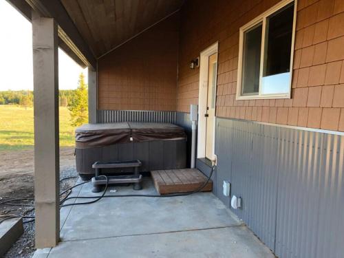 a porch with a bed on the side of a house at Patios, Hot Tub, Yellowstone in Rea