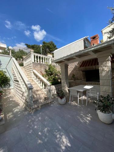 a patio with a table and a stairway with a table and chairs at Villa NIKA & KARLO Makarska in Makarska