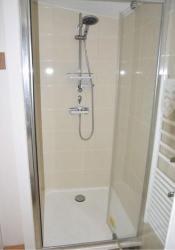 une douche avec une porte vitrée dans une salle de bain dans l'établissement Studio Canapé convertible 2 pers avec jardin et parking clos, à Merlimont
