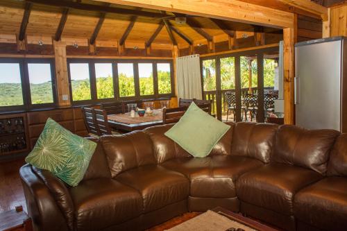 a brown leather couch in a living room with a table at Sodwana Bay Lodge House 34 in Sodwana Bay