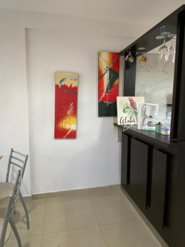 comedor con mesa y pinturas en la pared en Depto en Monte Grande a 15 minutos del Aeropuerto 4 Zona Residencial en Monte Grande