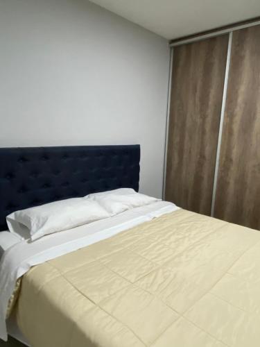 1 cama con cabecero azul en un dormitorio en Depto en Monte Grande a 15 minutos del Aeropuerto 4 Zona Residencial en Monte Grande