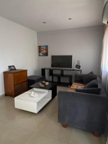 sala de estar con sofá y TV en Depto en Monte Grande a 15 minutos del Aeropuerto 4 Zona Residencial en Monte Grande
