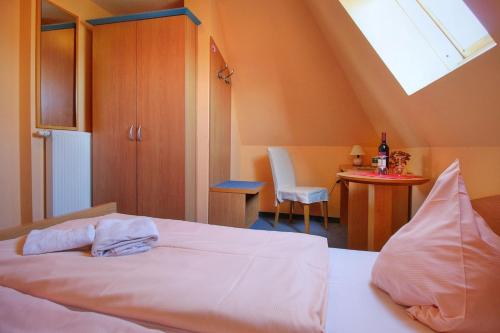 a bedroom with a bed and a table and a window at Pension Mola in Breege