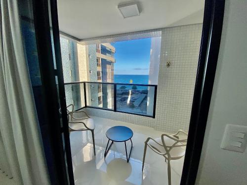 a room with a balcony with a view of the ocean at Edifício SKY Apto 918 - ER Hospedagens in Maceió