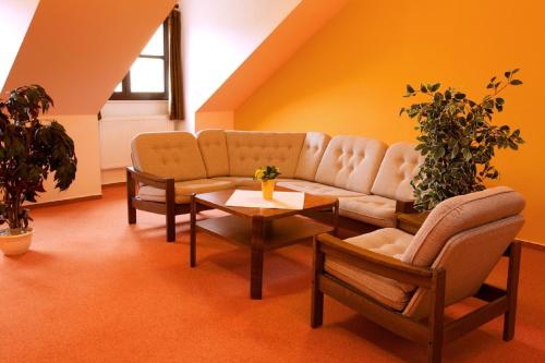 a living room with a couch and chairs and a table at Hotel Floret in Prŭhonice