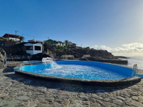 a swimming pool on the beach next to the ocean at Marea La Caleta El Hierro in La Caleta